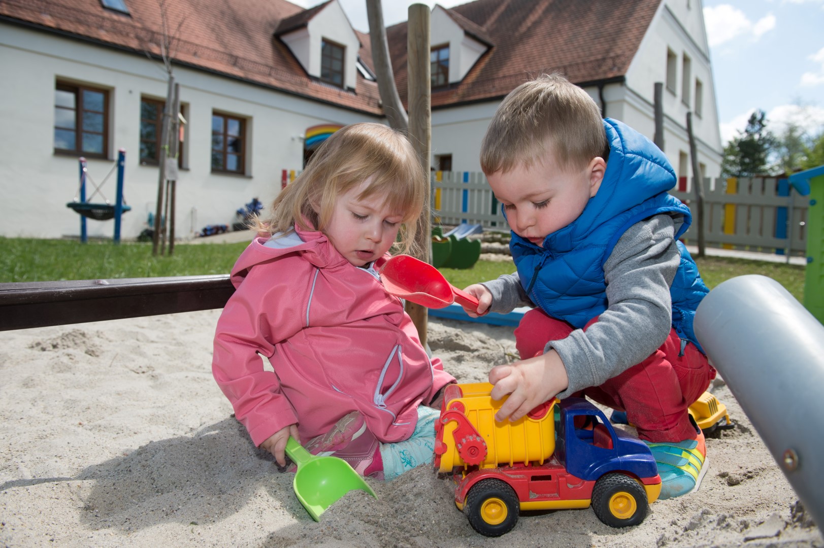 Kinder  im Sandkasten vor der Flohkiste